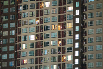 Fototapeta na wymiar Apartment windows at night. Urban city living vibe.
