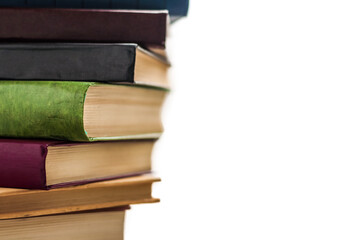 A stack of books on a white background, close-up, color covers, yellow pages