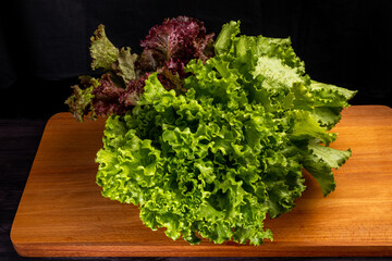 fresh green and red lettuce on wooden cutting board