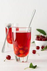 Summer delicious cherry compote with pulp in glasses on a white background