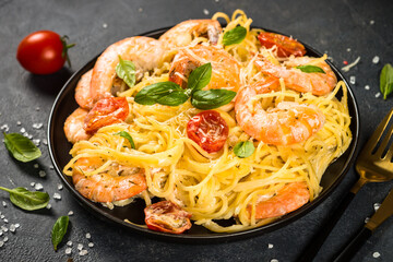 Pasta seafood with shrimp on black table.