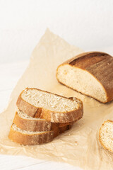 Loaf of homemade bread with sliced bread from wheat and seeds on parchment paper