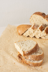 Loaf of homemade bread with sliced bread from wheat and seeds on parchment paper