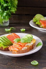 Different delicious sandwiches for breakfast, bread with cheese, avocado and trout, sandwich with egg and parsley with basil