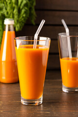 Natural carrot juice with pulp sugar-free in glasses on a wooden table