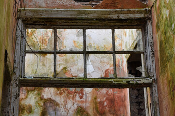 Interior of derelict building showing broken window, mould and peeling paint