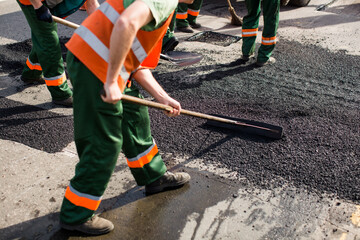 Workers on Asphalting paver machine during Road street repairing works. Street resurfacing. Fresh...