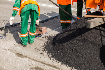 The man working asphalt pouring tar for road repair
