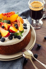 Coconut Cake with whipped coconut cream and fresh fruits - peaches and blueberries and coffe close up
