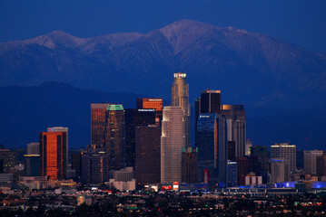 Obraz premium The skyline of Los Angeles glows under the massive San Gabriel Mountains