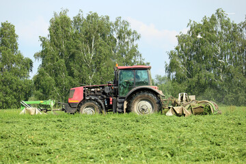 tractor mows green grass	