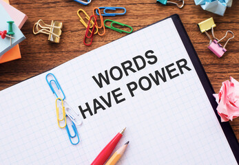 Words have power - inspirational handwriting in a notebook on wooden table with pen, crumpled paper...