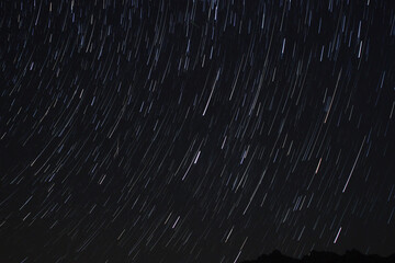 A view of the stars of the Milky Way with a mountain top in the foreground. Night sky nature summer...