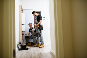 Full length shot of aged electrician, repairman in uniform working, installing ethernet cable or...