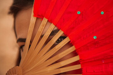 Woman standing in desert with red fans