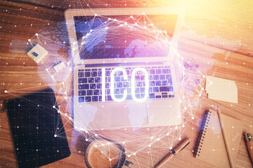 Blockchain theme hologram drawings over computer on the desktop background. Top view. Multi...