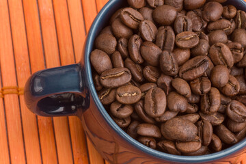 close up, blue mug with coffee beans on an orange texture