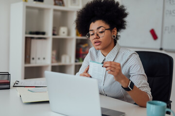 Virtual Classroom. Young afro american female teacher explaining something while teaching through webcam at home