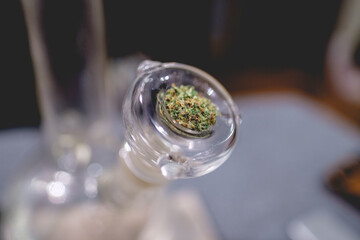 Transparent glass marijuana water bong (cannabis pipe) with green and beautiful pot