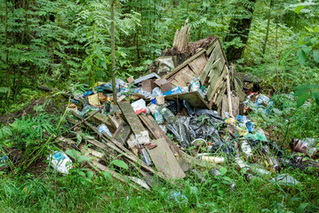 A large pile of garbage, waste in the forest. The nature of forests is polluted by humans. Ecology pollution disaster danger.