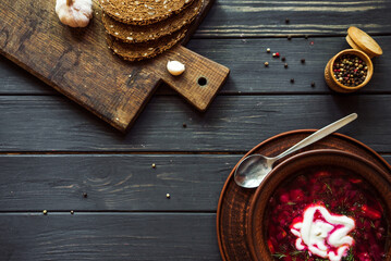 Ukrainian borsch with bread, sour cream, garlic and a mixture of peppers
