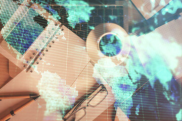 Double exposure of business theme hologram over desktop with phone. Top view. Mobile international...