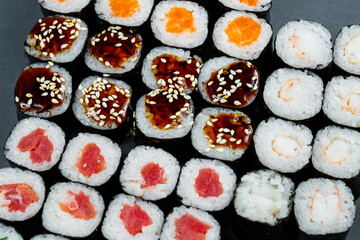 Japanese food. Rolls with ripe avocado, red fish, salmon, fresh rice with vegetables in nori. Set with rolls