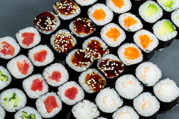 Japanese food. Rolls with ripe avocado, red fish, salmon, fresh rice with vegetables in nori. Set with rolls