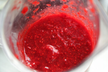 Girl makes berry jam in a blender