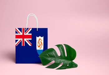 Anguilla shopping concept. National cardboard shopping bag with monstera leaf and pink background. Online shopping theme.