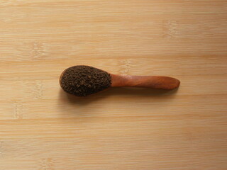 Brown color dry tea leaves on wooden spoon