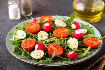 Healthy salad with arugula, quaill eqqs and cherry tomatoes. Diet food concept.
