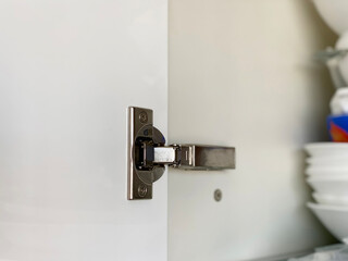 A fitted door hinge inside kitchen cupboard. Kitchen furniture