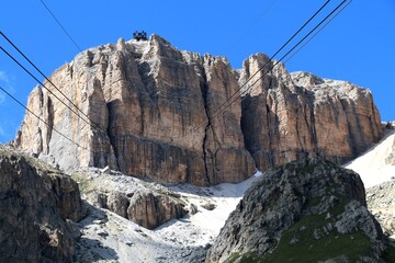 view up from Sass Pordoi to Terraza della Dolomiti funicular station, Sella mountain range, dolomites with blue sky