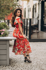 Woman in red dress poses on the street.Soft selective focus