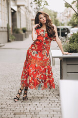 Woman in red dress poses on the street.Soft selective focus