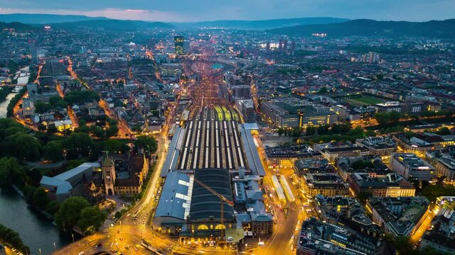 sunset illuminated zurich cityscape central train station aerial panoramic 4k timelapse switzerland