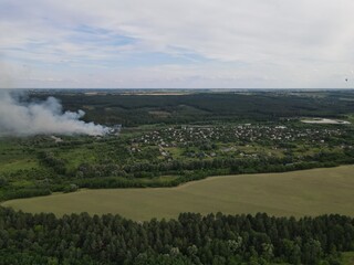 Fire and white smoke with rural summer landscape