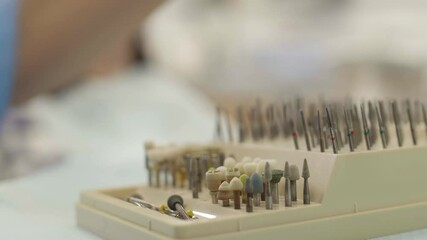 Close up of unrecognizable dentist hand wearing medical glove taking one of the surgical tools from surgical kit for dental implantology