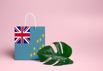 Tuvalu shopping concept. National cardboard shopping bag with monstera leaf and pink background....