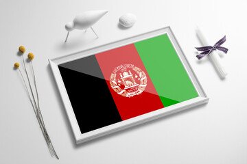 Afghanistan flag in wooden frame on table. White natural soft concept, national celebration theme.