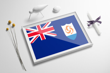 Anguilla flag in wooden frame on table. White natural soft concept, national celebration theme.
