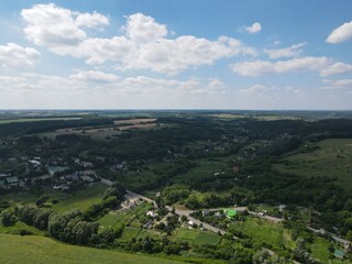 Fototapeta premium Aerial view of yellow and green fields in summer with blue sky and white clouds