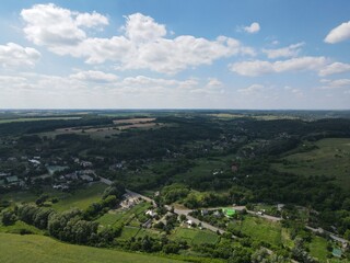 Aerial view of yellow and green fields in summer with blue sky and white clouds