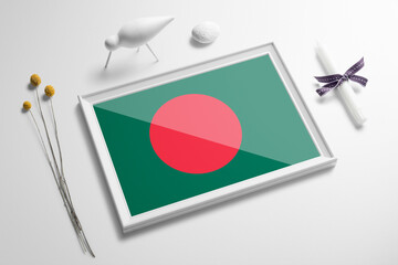Bangladesh flag in wooden frame on table. White natural soft concept, national celebration theme.