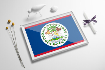 Belize flag in wooden frame on table. White natural soft concept, national celebration theme.