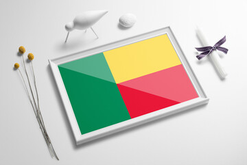 Benin flag in wooden frame on table. White natural soft concept, national celebration theme.