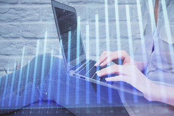 Multi exposure of woman hands typing on computer and forex chart hologram drawing. Stock market analysis concept.