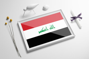 Iraq flag in wooden frame on table. White natural soft concept, national celebration theme.