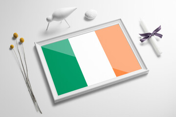 Ireland flag in wooden frame on table. White natural soft concept, national celebration theme.
